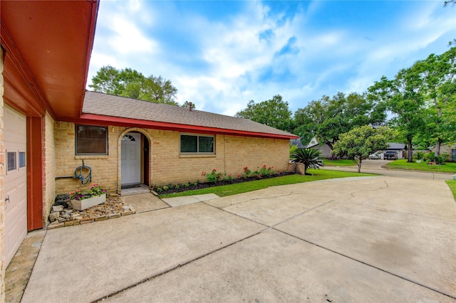 view of front of house featuring a shingled roof and brick siding