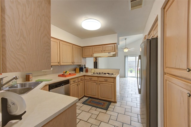 kitchen featuring light brown cabinets, stainless steel appliances, a sink, and a peninsula