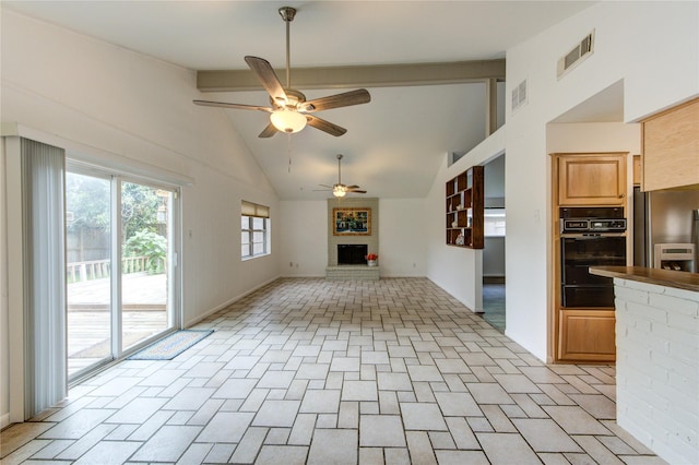 unfurnished living room featuring ceiling fan, a fireplace, beamed ceiling, and high vaulted ceiling