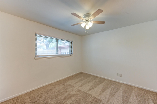 unfurnished room featuring light colored carpet, baseboards, and a ceiling fan