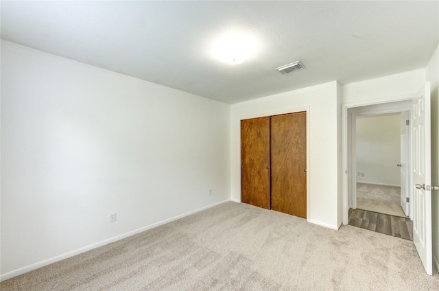 unfurnished bedroom featuring carpet, a closet, and baseboards