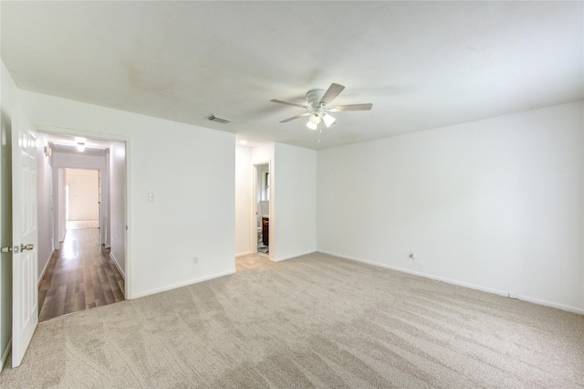 unfurnished room featuring light colored carpet, ceiling fan, and baseboards