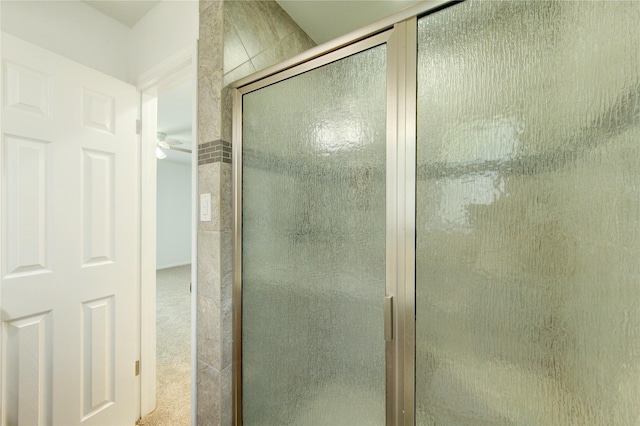 bathroom with a shower stall and ceiling fan