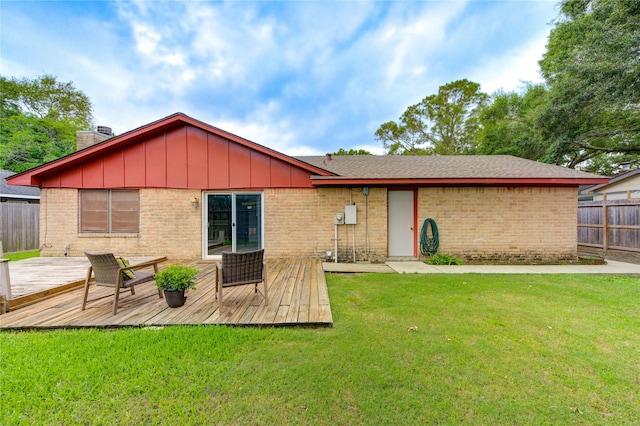 back of property featuring a wooden deck, brick siding, a chimney, and board and batten siding