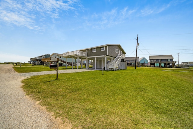119 Nesmith Pl, Surfside Beach, TX 77541 - view of front of home with stairs, a carport, driveway, and a front lawn