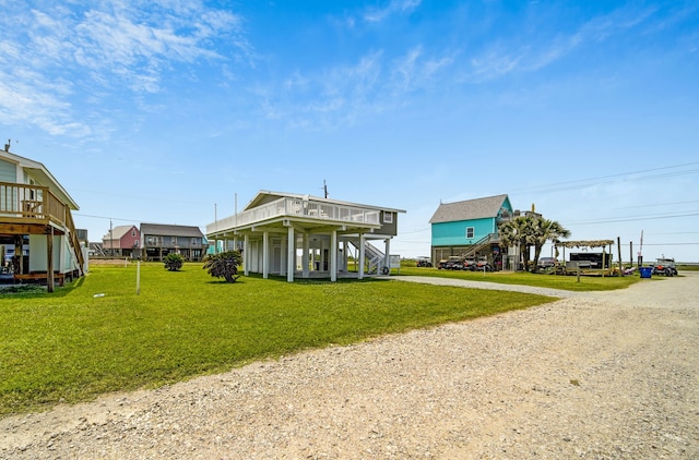 119 Nesmith Pl, Surfside Beach, TX 77541 - back of property with driveway, a yard, and stairs
