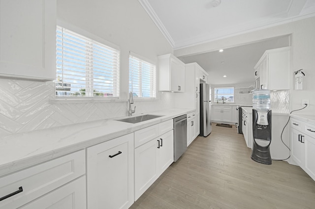 119 Nesmith Pl, Surfside Beach, TX 77541 - kitchen with a sink, appliances with stainless steel finishes, crown molding, backsplash, and white cabinets