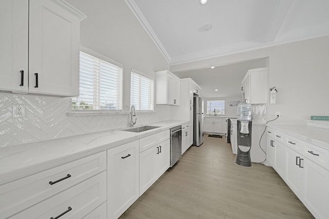119 Nesmith Pl, Surfside Beach, TX 77541 - kitchen with stainless steel appliances, a sink, ornamental molding, white cabinets, and backsplash