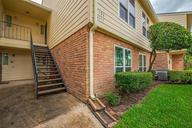 14555 Wunderlich Dr Unit 2307, Houston, TX 77069 - view of home's exterior featuring stairway, brick siding, and cooling unit