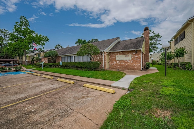 14555 Wunderlich Dr Unit 2307, Houston, TX 77069 - single story home featuring brick siding, a chimney, uncovered parking, a front yard, and roof with shingles