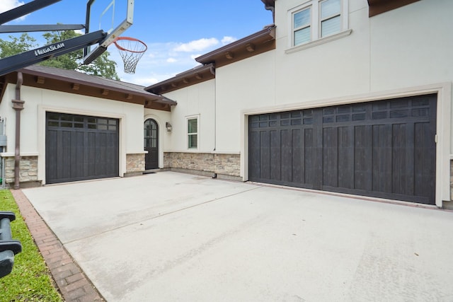 4606 W Alabama St, Houston, TX 77027 - view of front facade with stone siding, stucco siding, driveway, and a garage