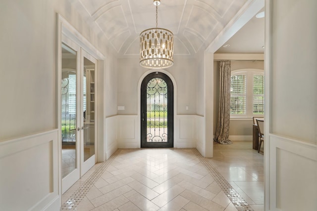 4606 W Alabama St, Houston, TX 77027 - foyer entrance featuring a chandelier, inlaid floor details, french doors, a decorative wall, and wainscoting
