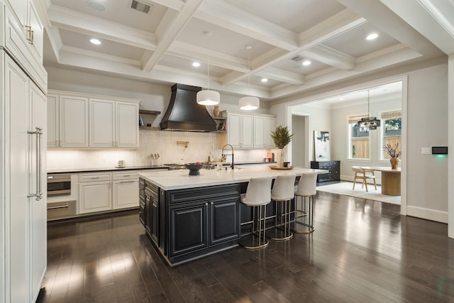 4606 W Alabama St, Houston, TX 77027 - kitchen with custom exhaust hood, dark wood finished floors, tasteful backsplash, beamed ceiling, and a kitchen island with sink