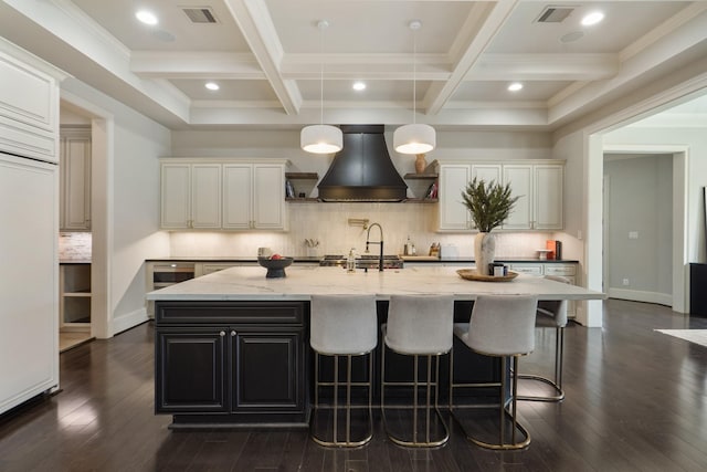4606 W Alabama St, Houston, TX 77027 - kitchen featuring custom exhaust hood, beam ceiling, a spacious island, dark wood finished floors, and light stone countertops