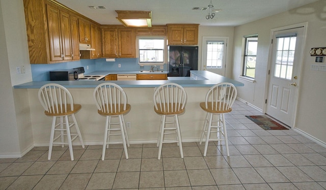 5361 County Road 868e, Brazoria, TX 77422 - kitchen with black fridge with ice dispenser, a sink, light countertops, baseboards, and a peninsula