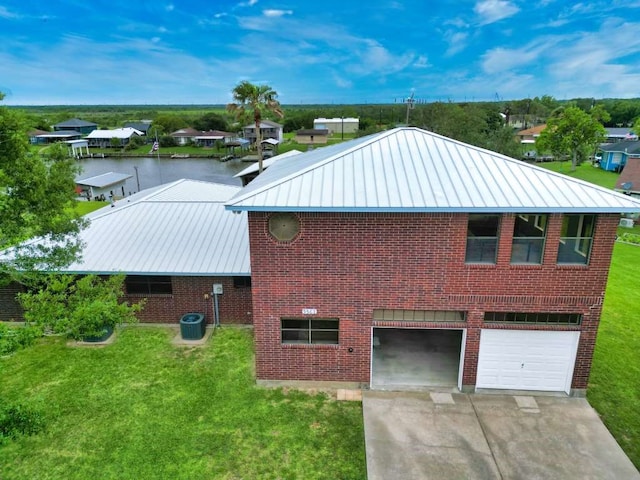 5361 County Road 868e, Brazoria, TX 77422 - view of property exterior featuring a standing seam roof, metal roof, a yard, concrete driveway, and a garage
