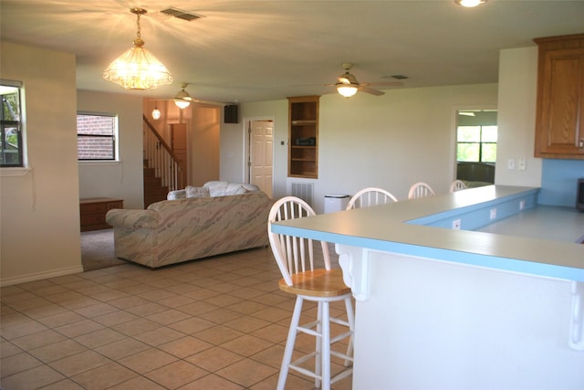 5361 County Road 868e, Brazoria, TX 77422 - kitchen with a breakfast bar area, a peninsula, ceiling fan, light countertops, and light tile patterned floors