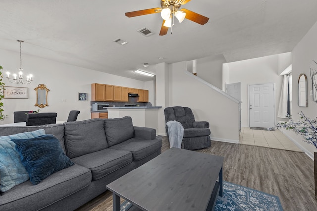 15914 Langhamwood Ln, Houston, TX 77084 - living room with a chandelier, ceiling fan, wood finished floors, baseboards, and stairs