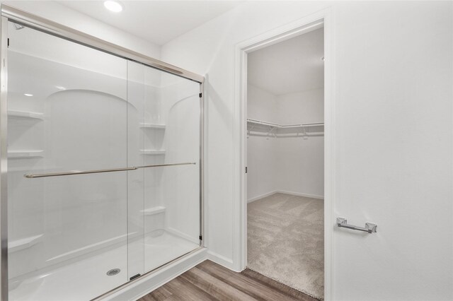 27214 Leeward Jetty Dr, Katy, TX 77493 - full bathroom with a stall shower, wood finished floors, a walk in closet, and baseboards