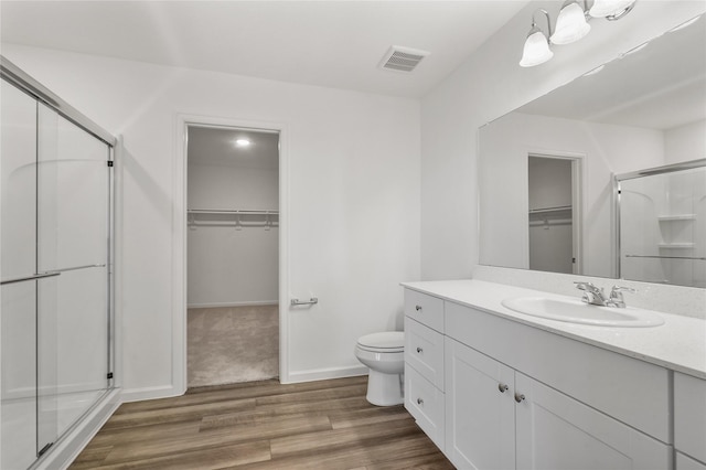 27214 Leeward Jetty Dr, Katy, TX 77493 - full bathroom featuring a stall shower, toilet, wood finished floors, vanity, and a walk in closet