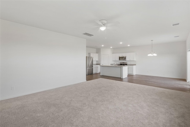 27214 Leeward Jetty Dr, Katy, TX 77493 - unfurnished living room featuring dark colored carpet, a ceiling fan, a chandelier, recessed lighting, and baseboards