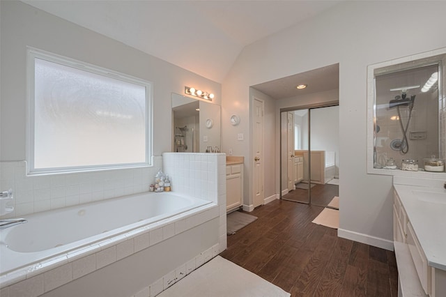full bathroom featuring vanity, tiled shower, a garden tub, wood finished floors, and lofted ceiling