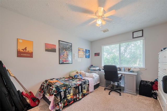 bedroom with carpet floors, a textured ceiling, ceiling fan, and a desk