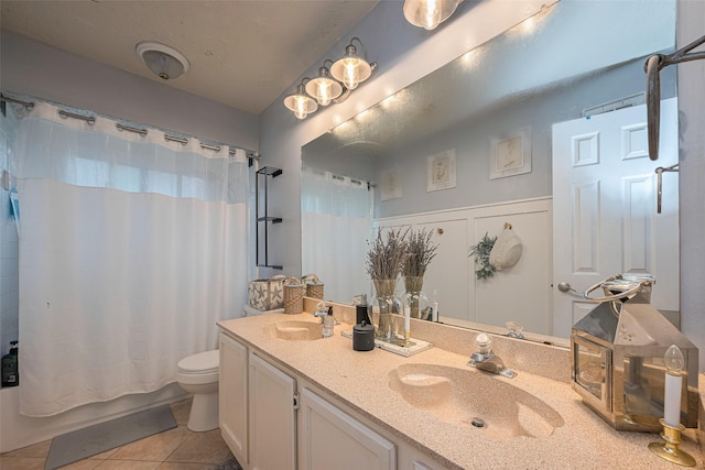 bathroom featuring tile patterned flooring, toilet, double vanity, and shower / tub combo with curtain