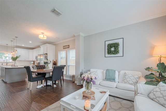 living room featuring ornamental molding, dark wood-type flooring, a textured ceiling, baseboards, and recessed lighting