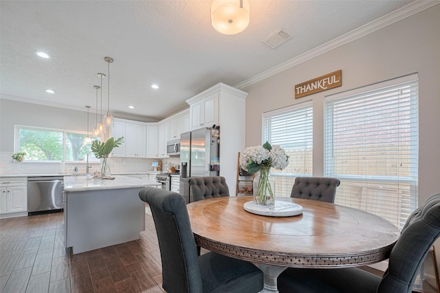 dining space featuring ornamental molding, dark wood-style floors, and recessed lighting