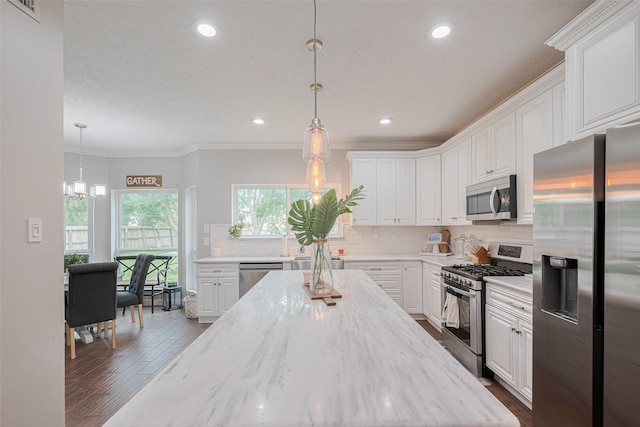 kitchen with stainless steel appliances, white cabinetry, recessed lighting, and crown molding
