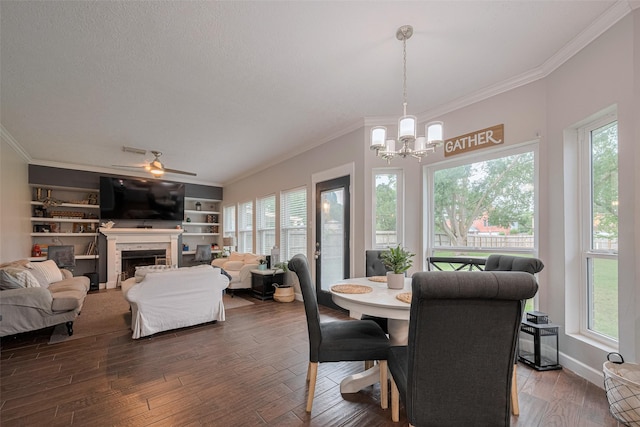 dining room with crown molding, plenty of natural light, a chandelier, a fireplace, and a textured ceiling