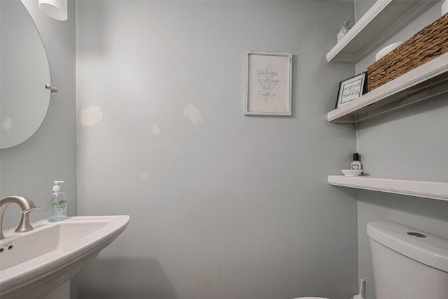 half bathroom featuring a sink and toilet