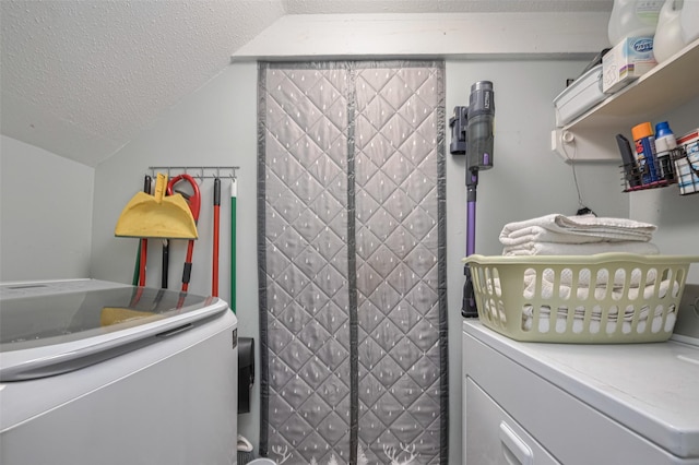 clothes washing area with a textured ceiling and separate washer and dryer
