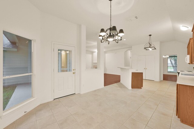 3722 Lovers Ln, Montgomery, TX 77356 - kitchen with a chandelier, light countertops, light tile patterned floors, vaulted ceiling, and brown cabinetry