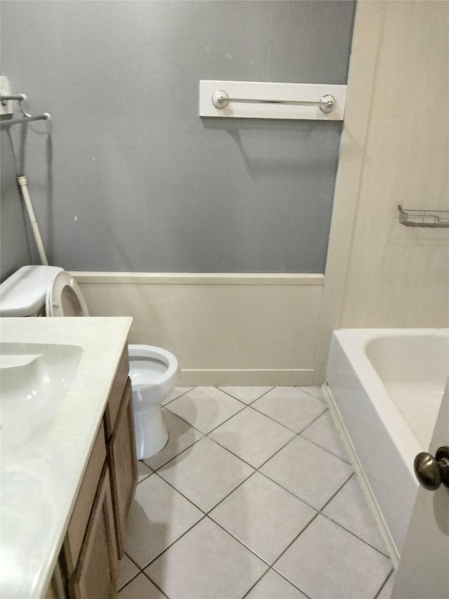 full bathroom featuring tile patterned floors, toilet, a tub, and vanity