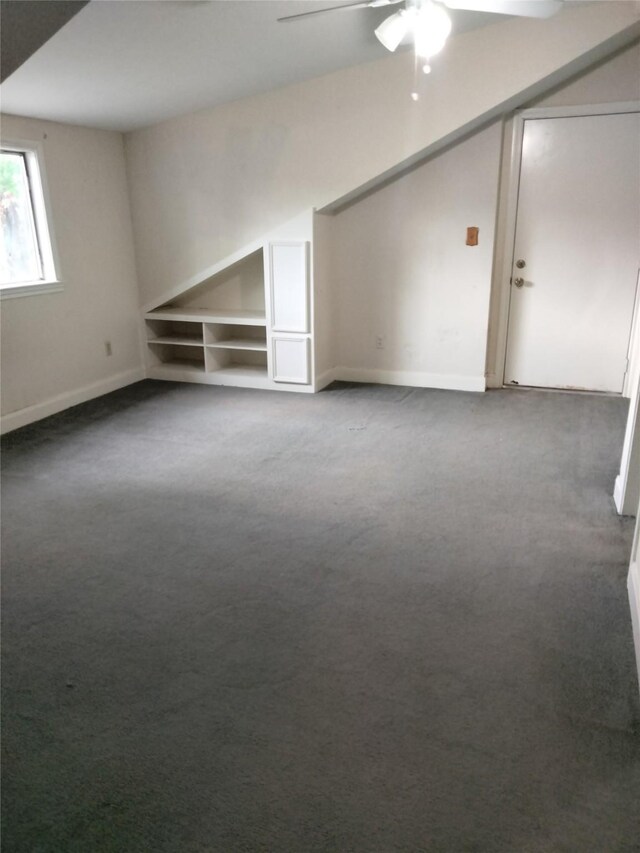 bonus room with a ceiling fan, carpet, and baseboards