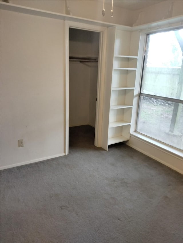 unfurnished bedroom featuring carpet floors, a closet, and baseboards