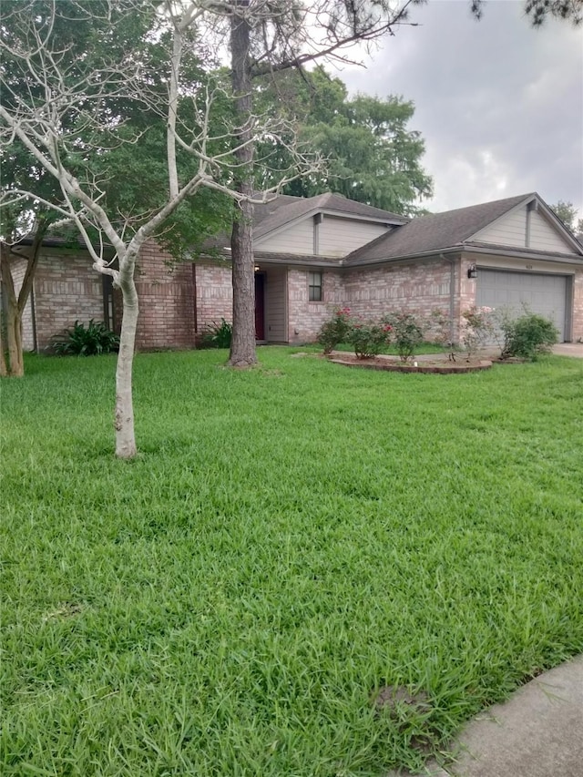 view of front of house featuring an attached garage, a front lawn, and brick siding