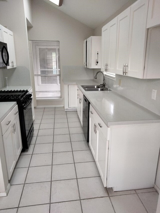 kitchen with a sink, black appliances, light tile patterned flooring, light countertops, and vaulted ceiling