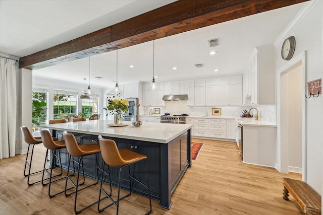 15411 Parkwood Way, Houston, TX 77059 - kitchen featuring under cabinet range hood, decorative backsplash, white cabinets, light countertops, and recessed lighting