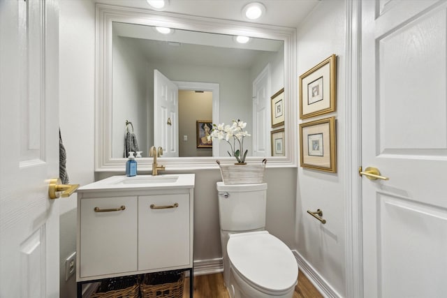 15411 Parkwood Way, Houston, TX 77059 - half bathroom with toilet, vanity, wood finished floors, and baseboards