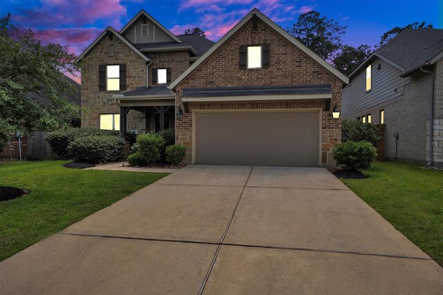 510 Pearl View Ln, Pinehurst, TX 77362 - view of front facade with stone siding, concrete driveway, a yard, and brick siding