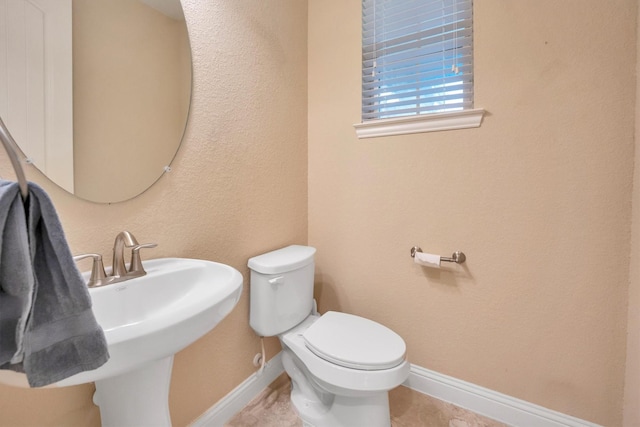 510 Pearl View Ln, Pinehurst, TX 77362 - half bathroom featuring baseboards, toilet, a sink, and tile patterned floors
