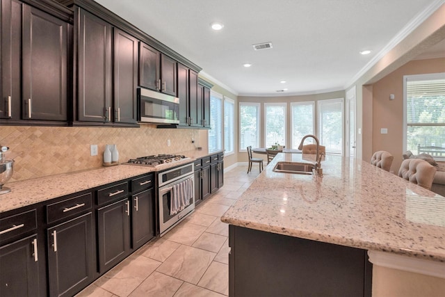 510 Pearl View Ln, Pinehurst, TX 77362 - kitchen featuring stainless steel appliances, a sink, ornamental molding, healthy amount of natural light, and decorative backsplash
