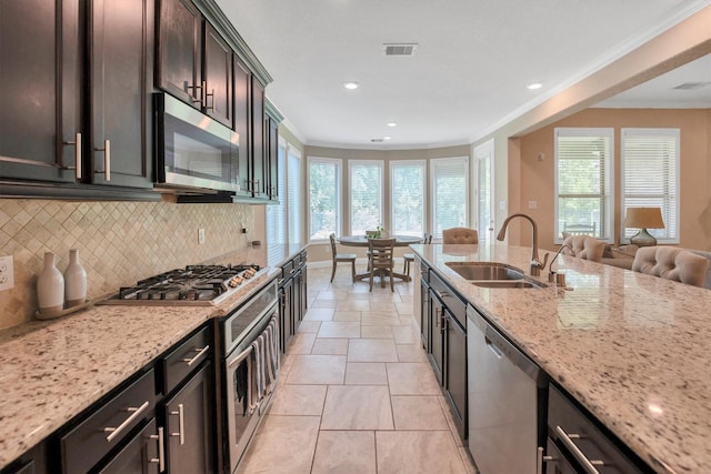 510 Pearl View Ln, Pinehurst, TX 77362 - kitchen with stainless steel appliances, a sink, backsplash, crown molding, and light stone counters