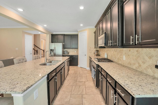 510 Pearl View Ln, Pinehurst, TX 77362 - kitchen featuring appliances with stainless steel finishes, a sink, ornamental molding, light stone counters, and a large island with sink