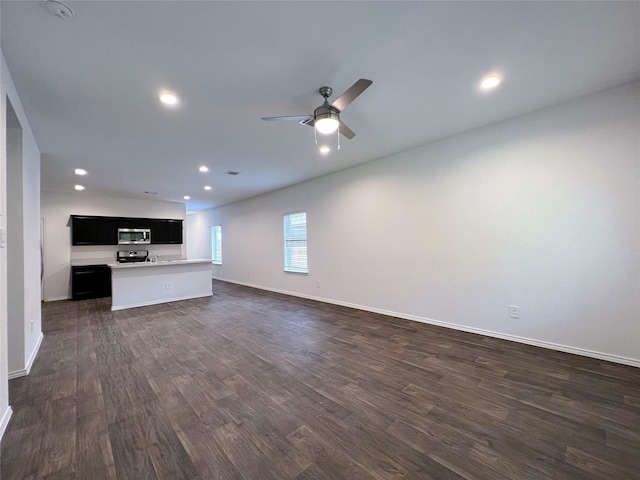 21310 Black Leaf Dr, New Caney, TX 77357 - unfurnished living room with dark wood-type flooring, baseboards, ceiling fan, and recessed lighting