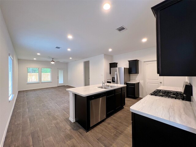 21310 Black Leaf Dr, New Caney, TX 77357 - kitchen featuring appliances with stainless steel finishes, dark cabinetry, light countertops, a sink, and recessed lighting