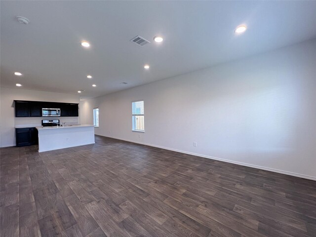 21310 Black Leaf Dr, New Caney, TX 77357 - unfurnished living room featuring dark wood-style flooring, recessed lighting, and baseboards